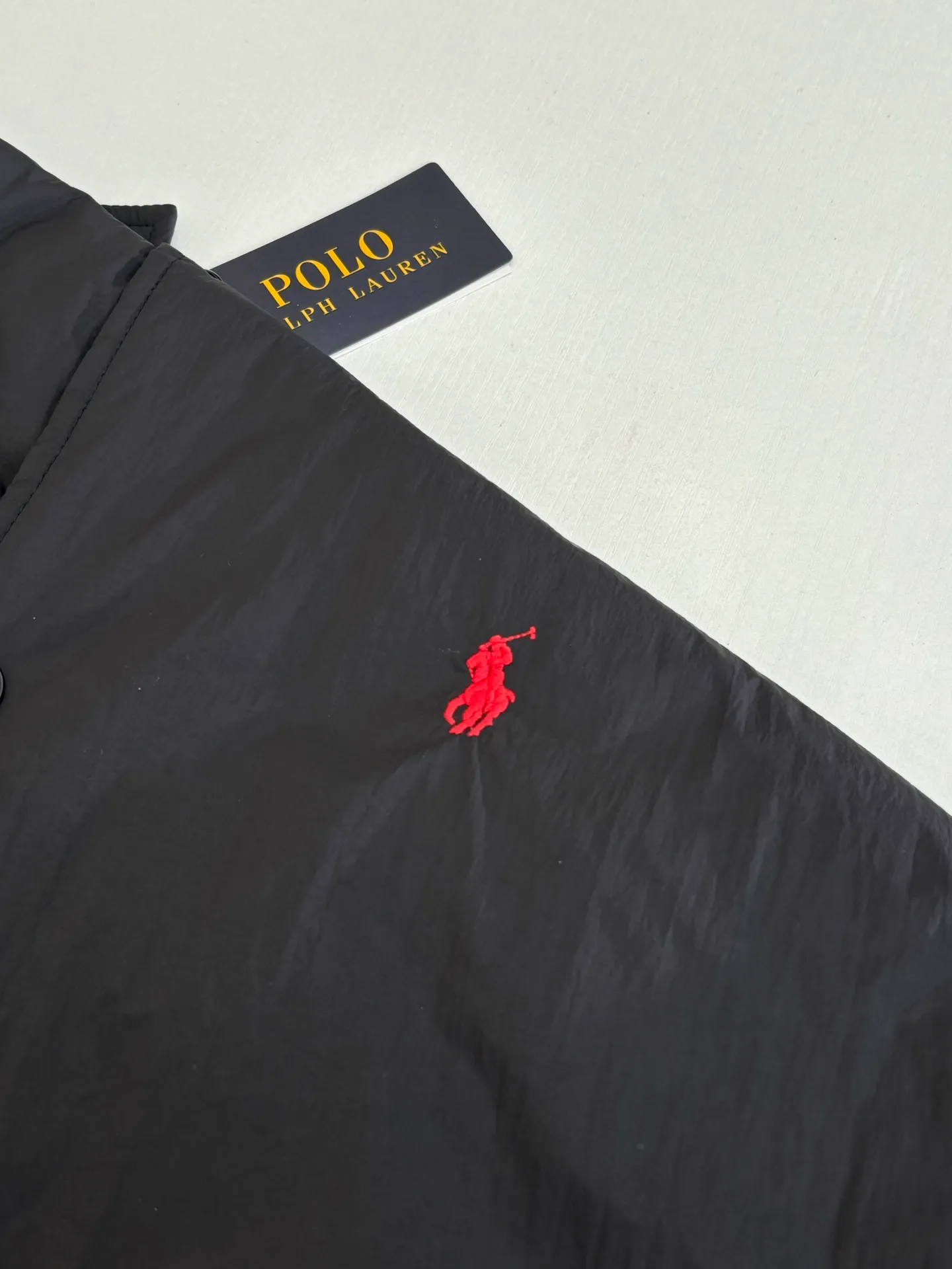 P670 Ralph Laure*/Ralph Lauren 25FW red label thin cotton coach jacket. The surface material is made of high-density nylon taffeta with a density of about 210T-300T. The surface is smooth and slightly matte. It has excellent windproof and waterproof performance (with DWR water-repellent treatment). It has strong wrinkle resistance and is easy to care for. It is in line with the positioning of American casual "durable and practical". Lining: Lightweight cotton-polyester blend lining (65% Polyester + 35% Cotton) Embroidery positioning: Precisely position through the template (12cm from the bottom of the neckline, 8cm from the placket) to ensure left and right symmetry and centering.  Size：S/M/L/XL